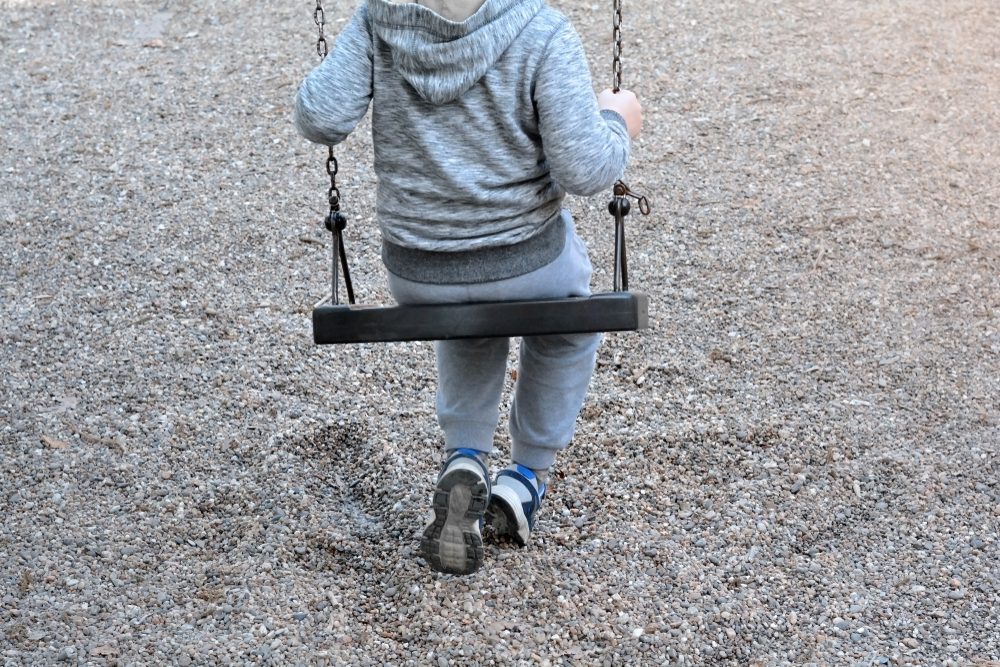 Boy Sitting On A Swing - Lonely Child Concept