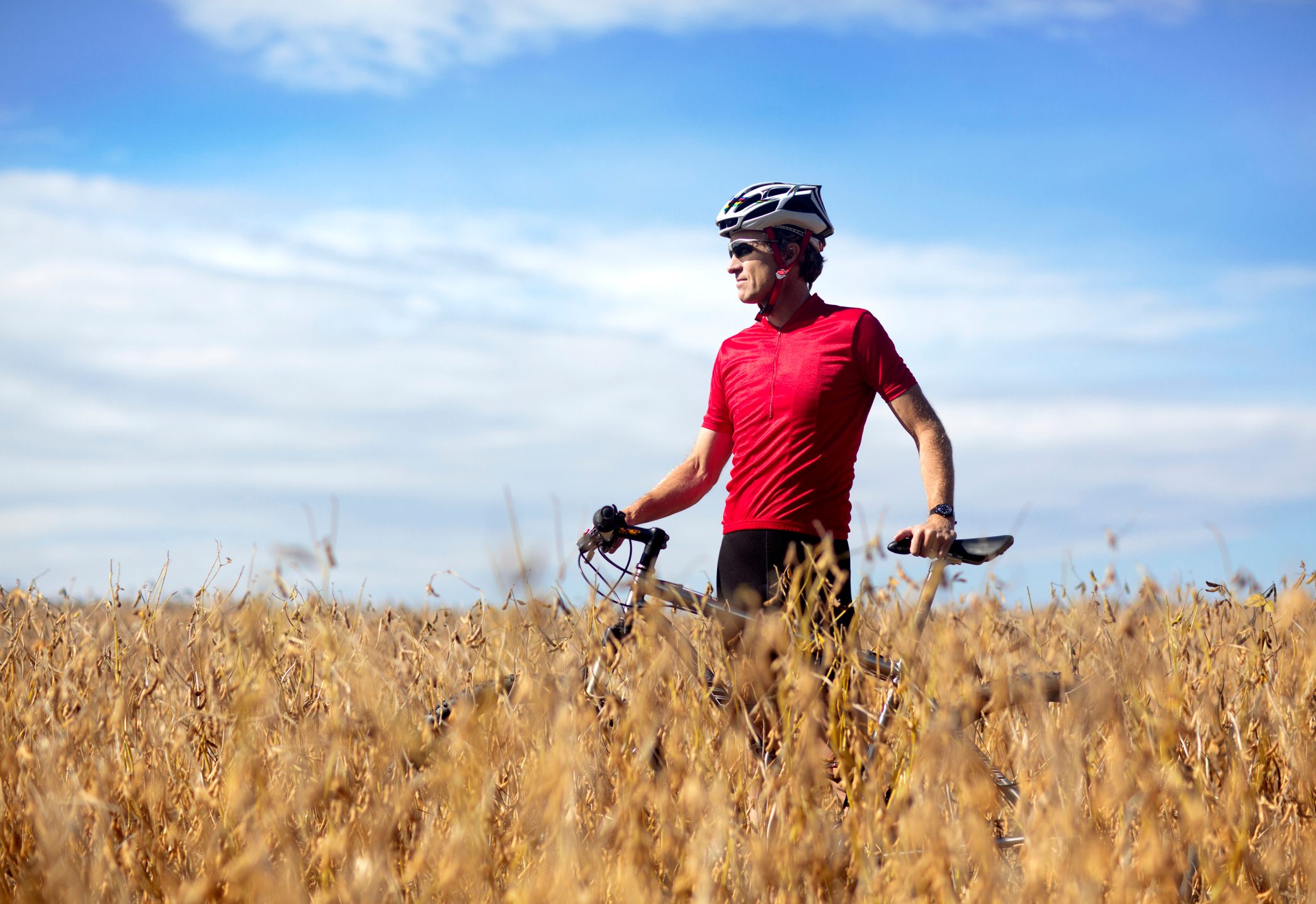 Off road biker stands in a farmer's field