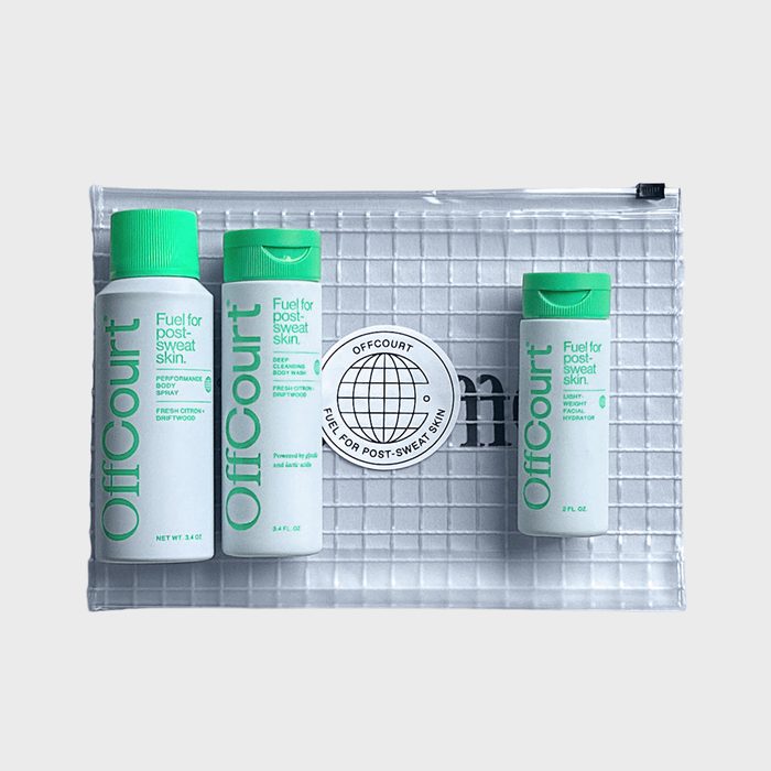 Three OffCourt skincare bottles stand inside a transparent, grid-patterned pouch; text reads 