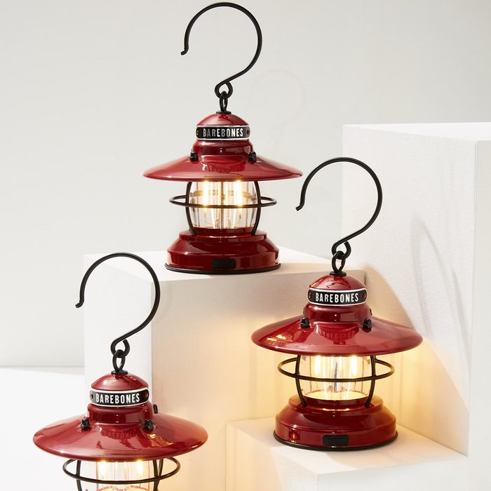 Red lanterns illuminate on white platforms; black hooks hang above. Text reads 
