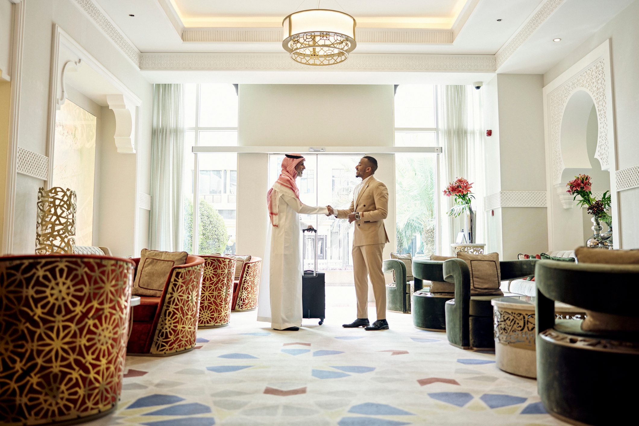Saudi businessman shaking hands with client in hotel lobby