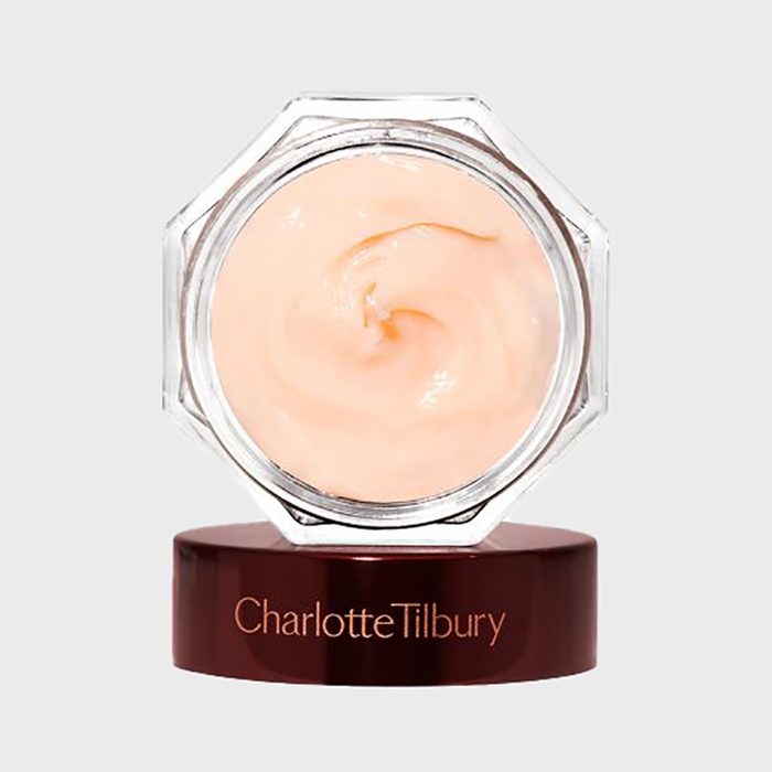A jar of light peach cream sits on a brown base labeled 