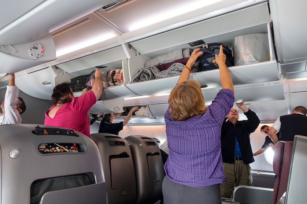 Australia, Melbourne Qantas airlines cabin business class passengers disembarking overhead luggage bins