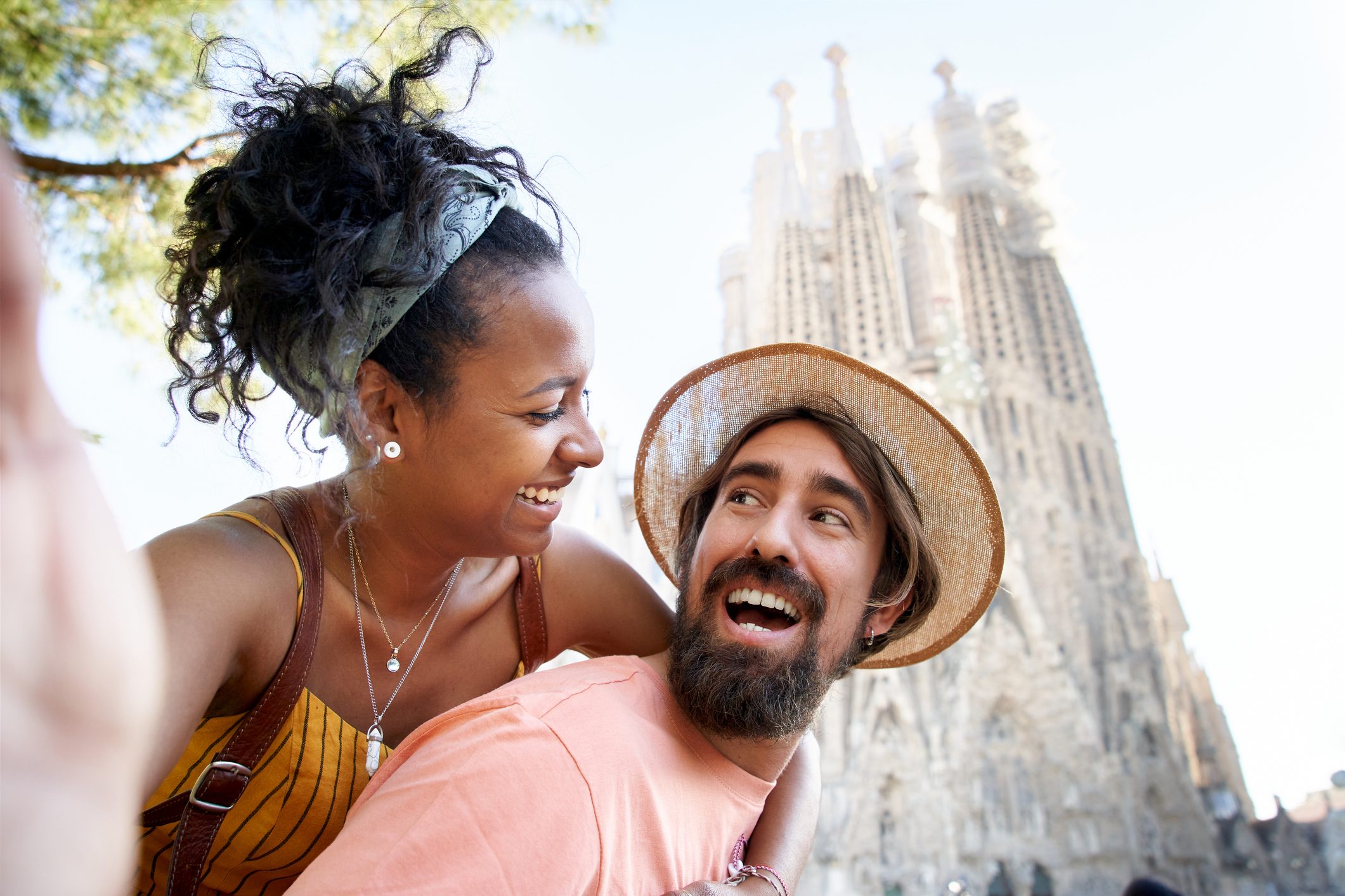 A happily just married couple taking a selfie with the Sagrada Familia behind.