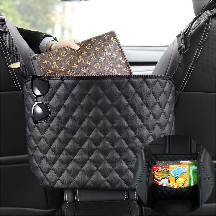 A quilted leather storage bag holds a wallet and sunglasses between car seats. Inset shows interior filled with colorful packages.