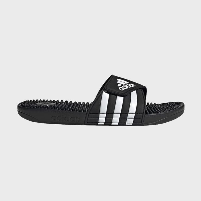 Black sports sandal, lying flat, showing three white stripes and textured footbed. 