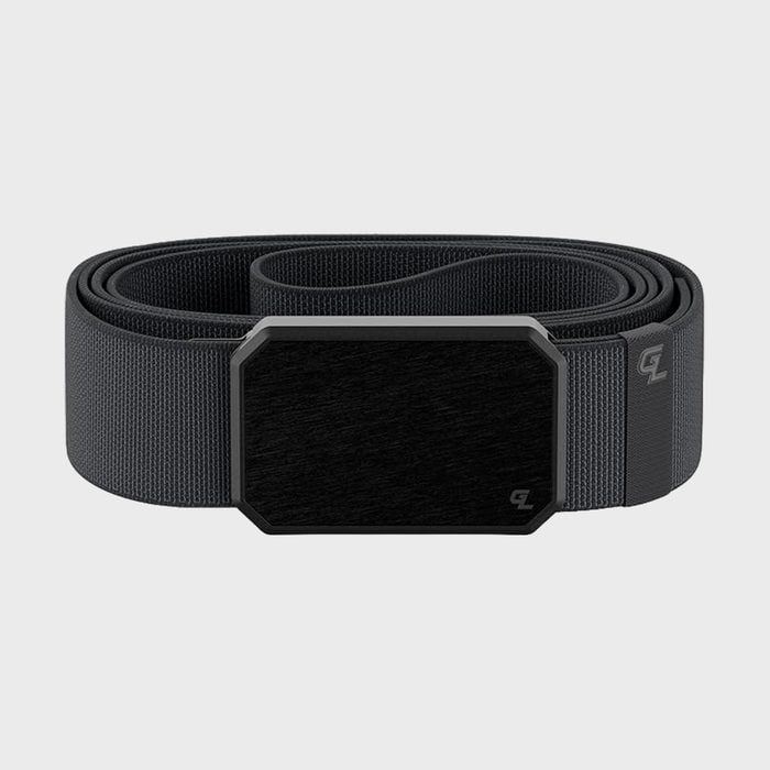 A black belt lies coiled with a sleek rectangular buckle against a plain gray background.
