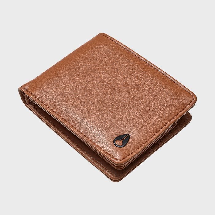 Brown leather wallet closed, resting on a plain white surface, featuring a small black emblem on the corner.