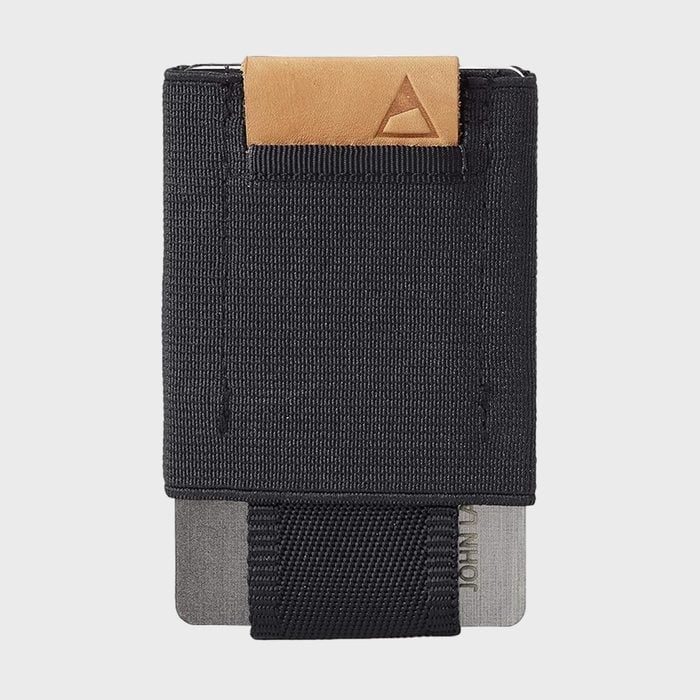 A black fabric wallet holds cards; one card partially visible. The wallet has a tan leather accent with a small triangle logo.