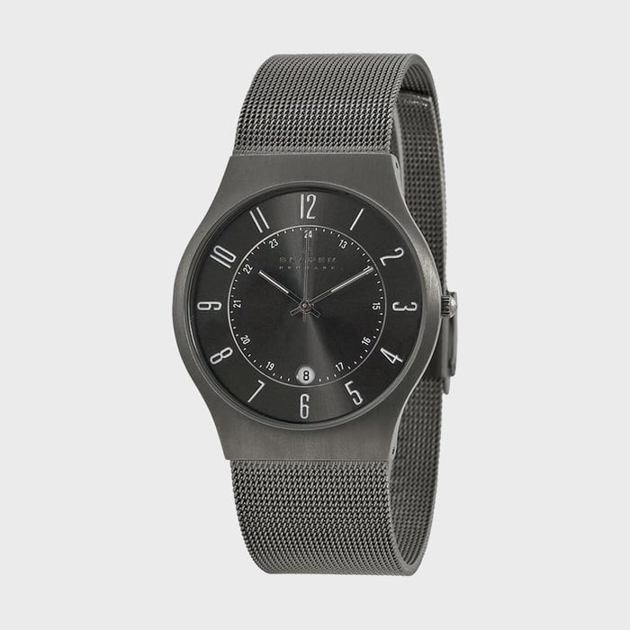 Watch displaying time, featuring a black face with white numbers, sleek metallic mesh band, set against a plain gray background.