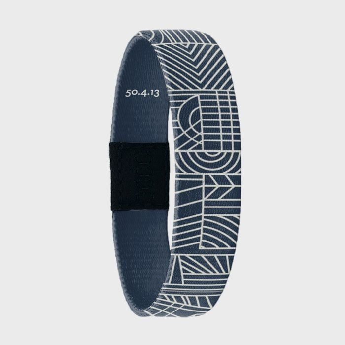Bracelet displays intricate geometric patterns, featuring white lines on a dark background. 