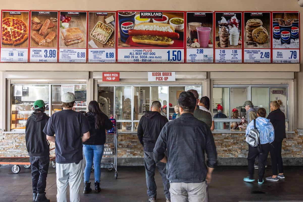 People wait in line at the food court at a Costco warehouse