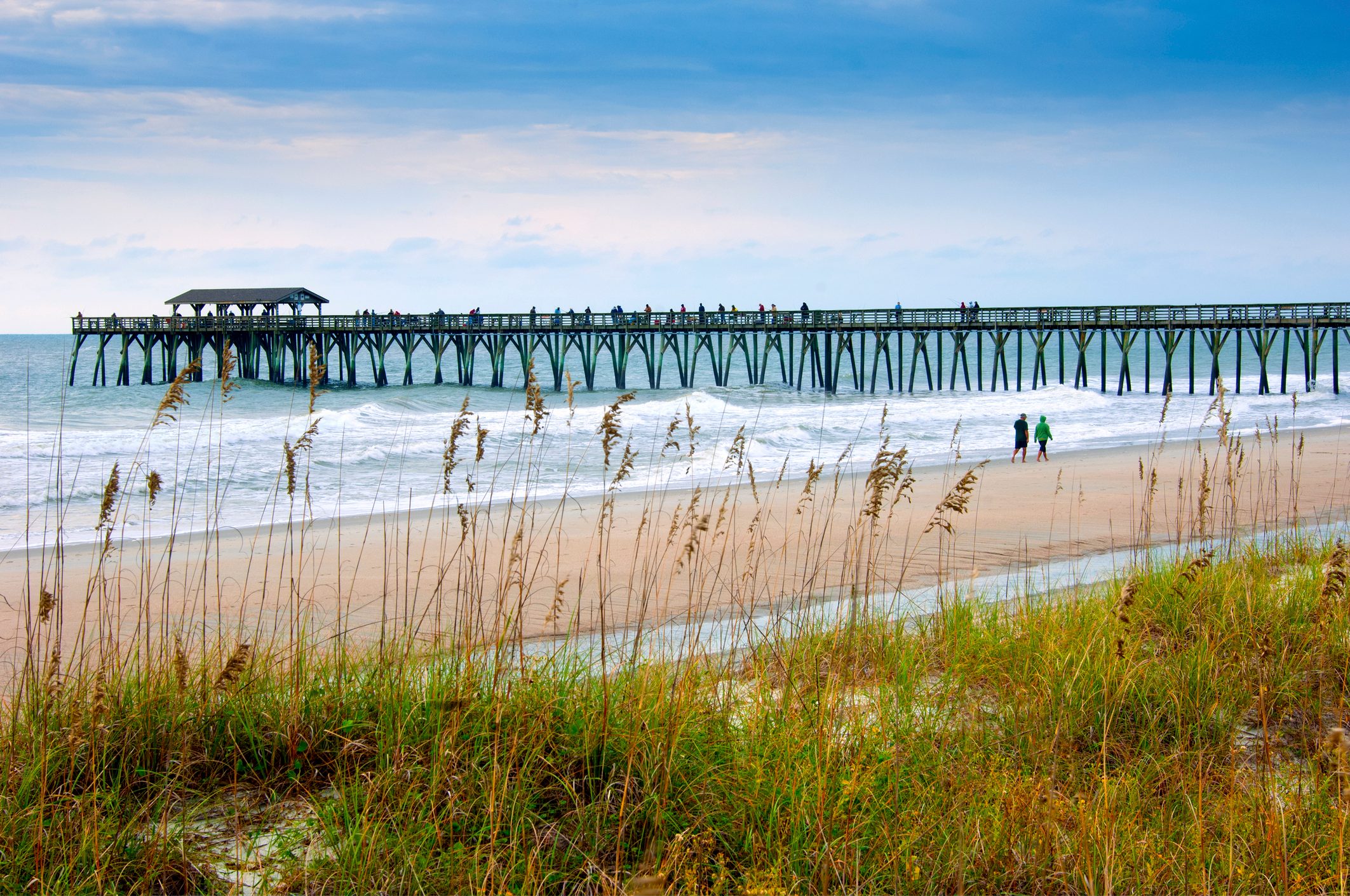 Beach with a long pier extending into the ocean