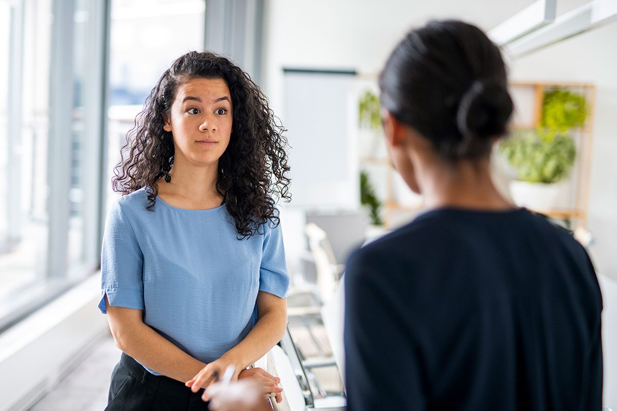 woman listening to her colleague complaining