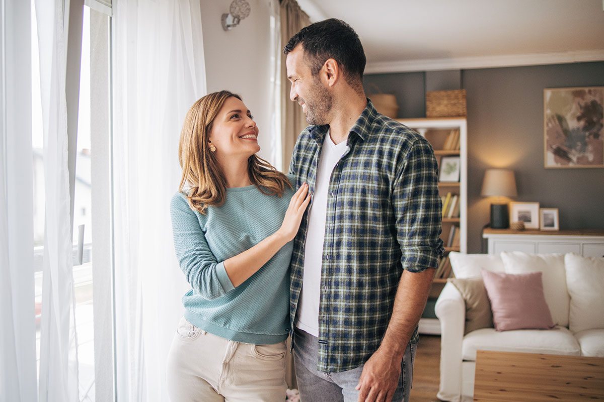 Portrait of a happy young couple smiling while standing together and looking at each other