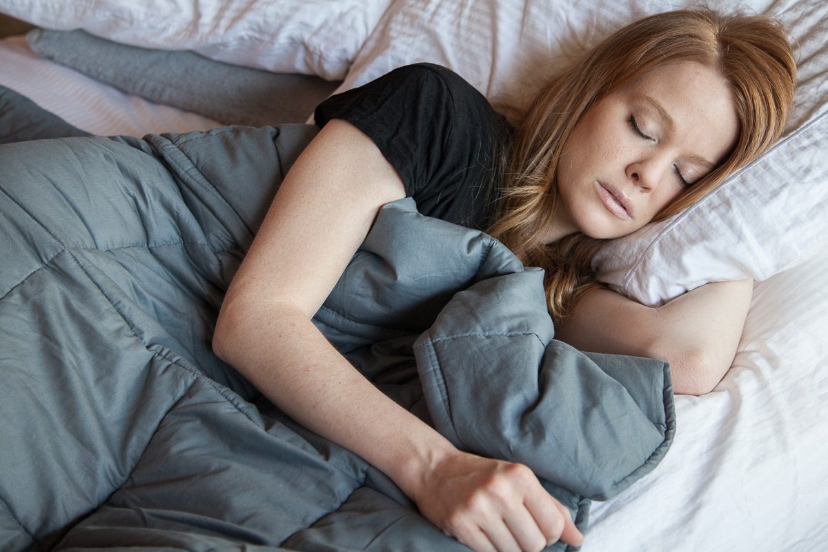 woman in bed with weighted blanket