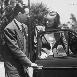 A Smartly Dressed Man Opens A Car Door For A Woman