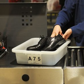 An air traveler places his shoes in a bin before passing through the Transportation Security Administration (TSA) security check at Los Angeles International Airport